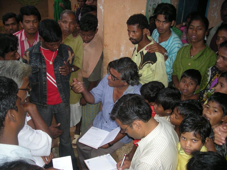 People gathered around person with notebook.